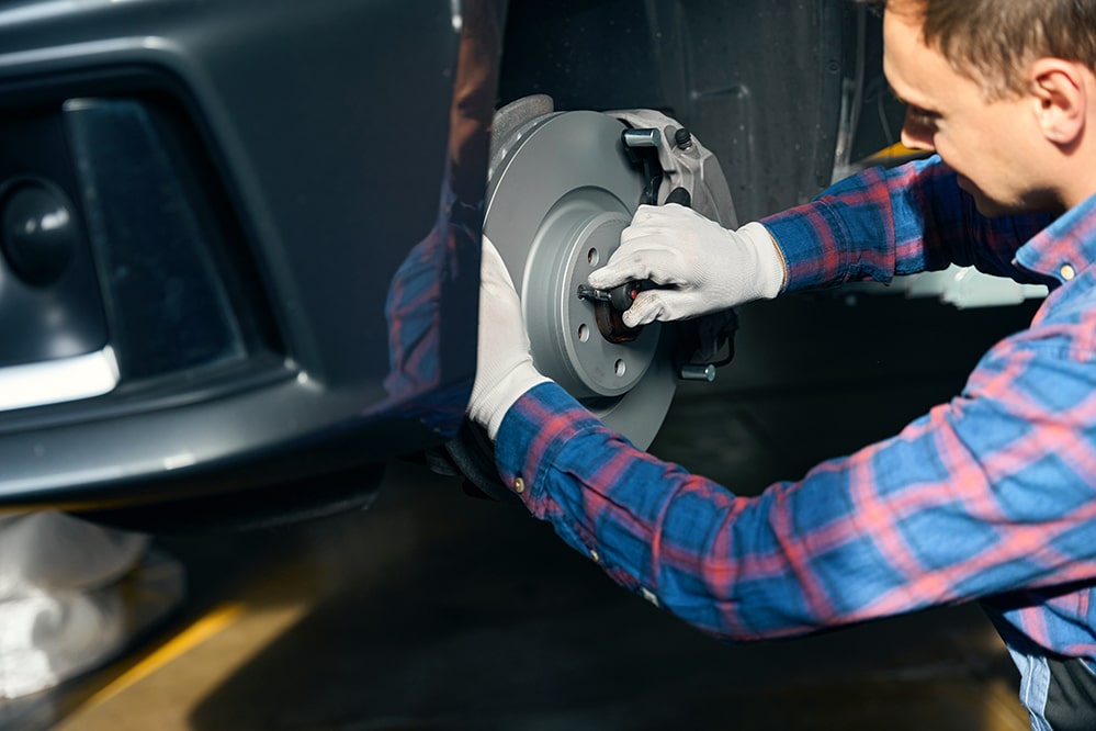 Mechanic checking car brake system at Dallas Complete Auto in Lancaster, Dallas, TX